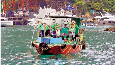 　　圖：海事處委託的承辦商，利用小船清理海上垃圾。\海事處提供