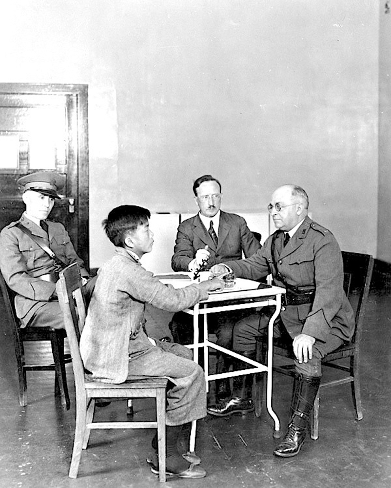 　　圖：一名中國男孩在天使島遭多人審問。 資料圖片