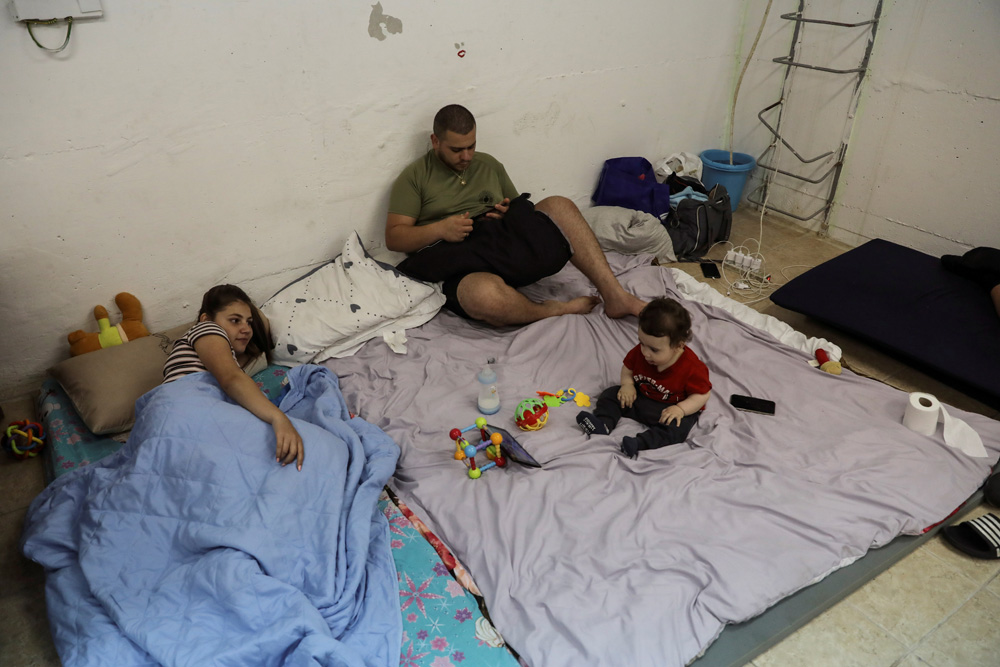 　　圖：以色列南部阿什克倫一個家庭18日藏身防空洞。\路透社