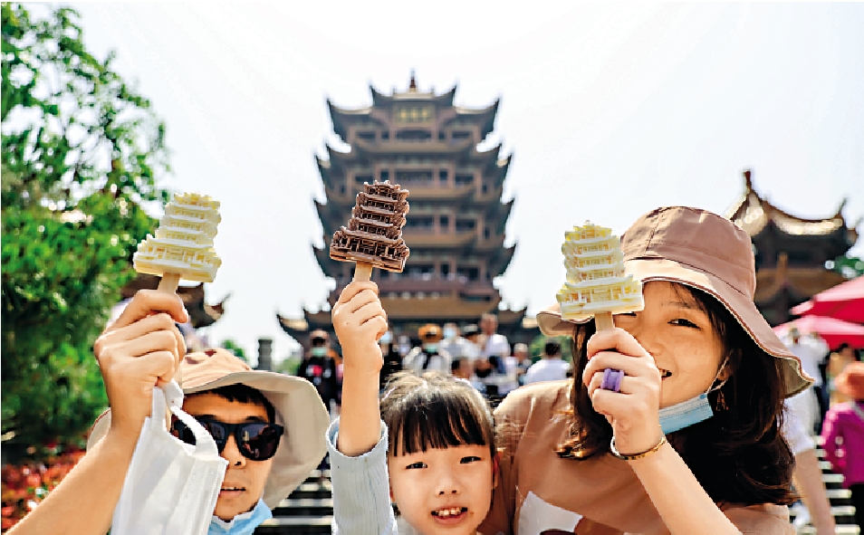 　　圖：今年「五一」假期，在武漢黃鶴樓前遊客手拿黃鶴樓網紅雪糕留影。/中新社