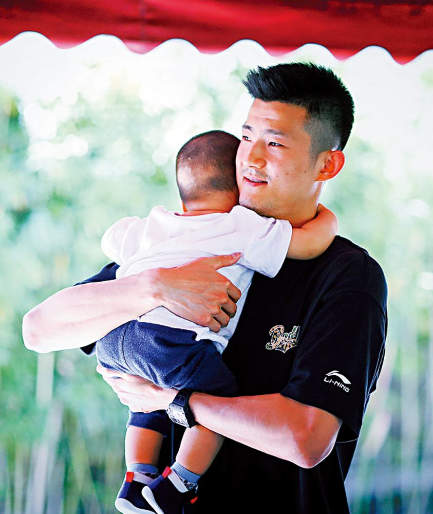 　　圖：諶龍抱着愛兒時，露出滿足表情。