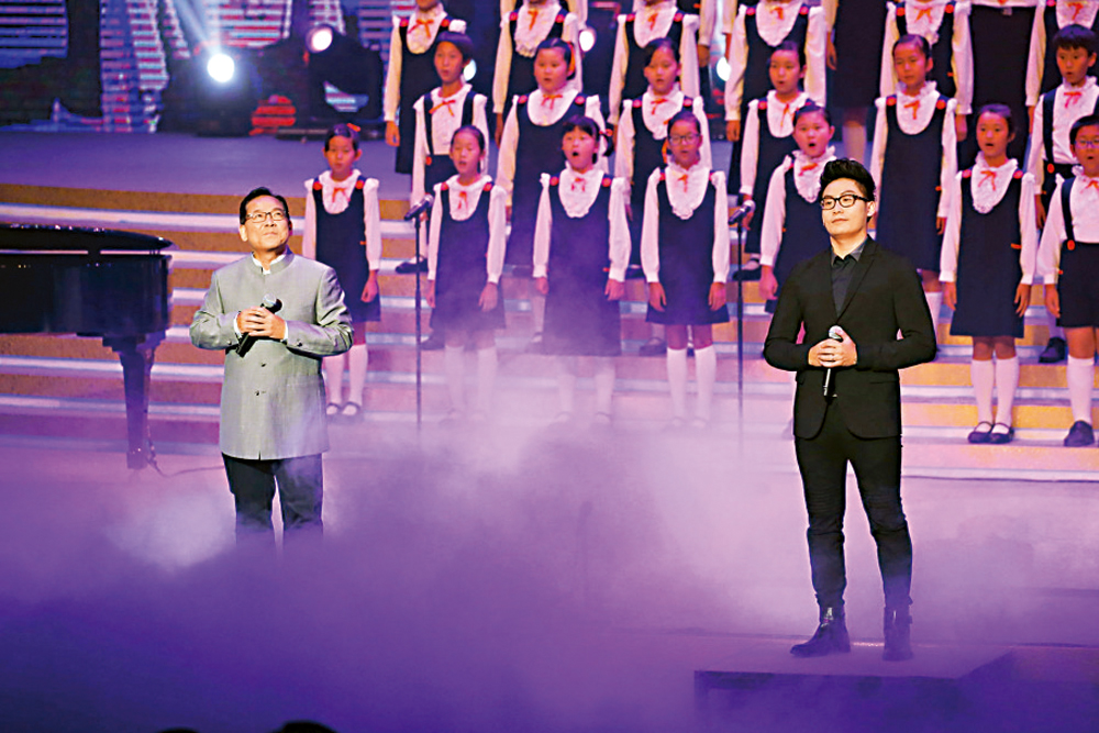 　　圖：張明敏（前排左）與兒子張頌華（前排右）2015年在文藝晚會上演唱《父子》。\資料圖片