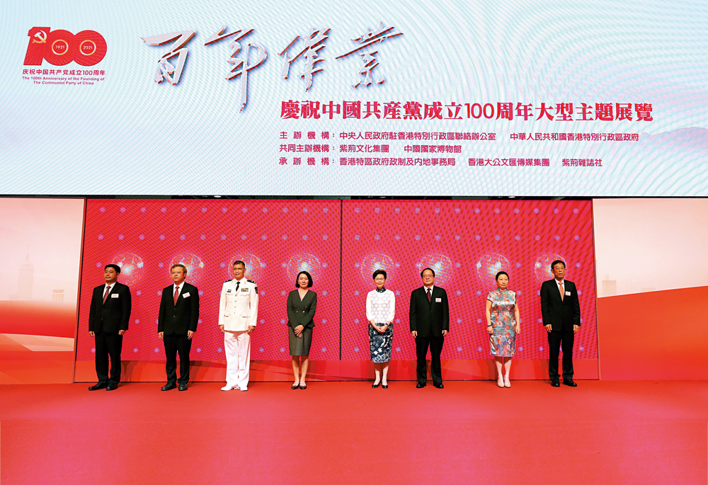 　　圖：「百年偉業──慶祝中國共產黨成立100周年大型主題展覽」在會展開幕，行政長官林鄭月娥（右四）、香港中聯辦副主任盧新寧（左四）、律政司司長鄭若驊（右二）、紫荊文化集團總經理文宏武（左二）、外交部駐港公署副特派員潘雲東（右三）、駐港部隊副司令員譚志偉（左三）、大文集團董事長姜在忠（右一）及紫荊雜誌社社長楊勇（左一）等嘉賓為開幕禮主禮。
