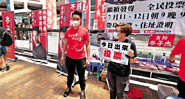 　　圖：消息指，曾參加攬炒派非法「初選」的區議員都將被取消資格，為怕被追討過百萬元薪津，不少人都急急辭職。圖為當日岑子杰在街站呼籲市民「投票」的情況。