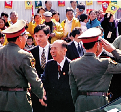 　　圖：1999年12月20日，澳門回歸祖國，馬萬祺和入駐澳門的解放軍官兵握手。\受訪者供圖