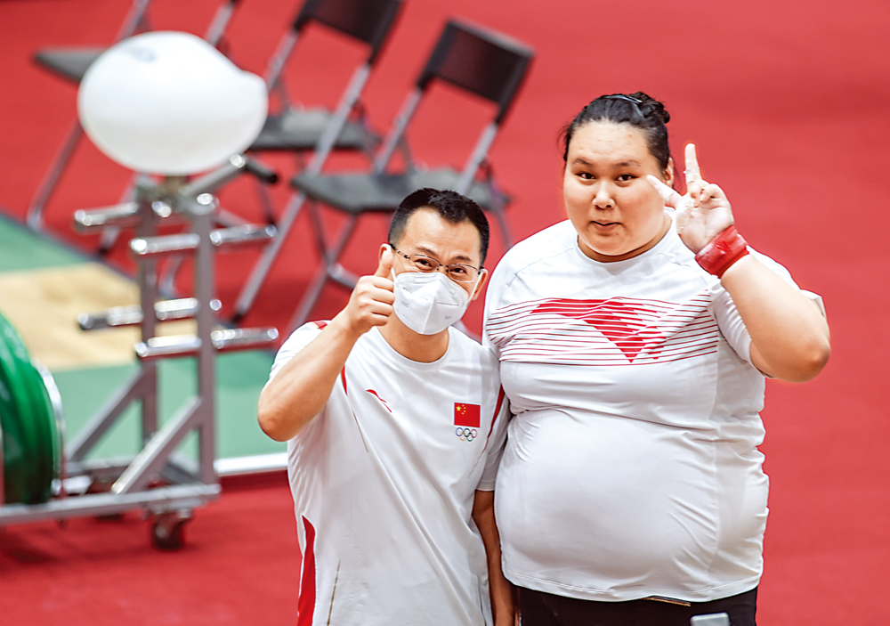 　　圖：中國女子舉重隊主教練張國政（左）和隊員李雯雯，在訓練後合照。\新華社