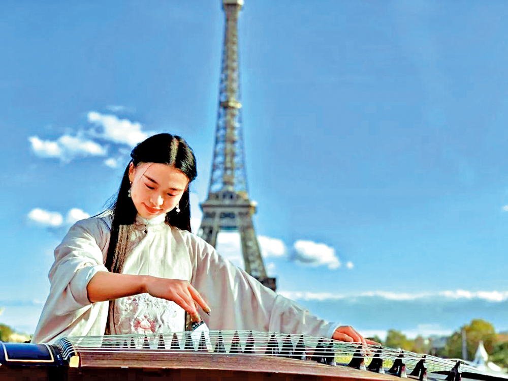 　　圖：彭靜旋在法國巴黎艾菲爾鐵塔下演奏古箏。\網絡圖片
