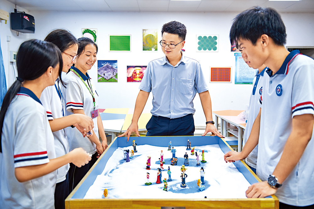 　　圖：首位在廣東技工院校入職的香港教師馮富榮通過沙盤給學生上心理輔導課。\受訪者供圖