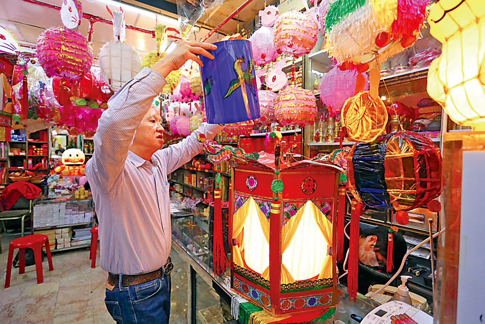 　　圖：詹偉強將圓筒形燈芯放入燈籠內，走馬燈製作就算完成。