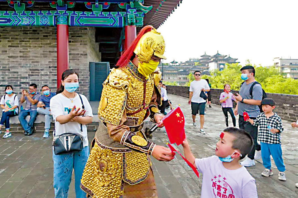 　　圖：西安城牆上「金甲武士」與遊客互動。\受訪者供圖