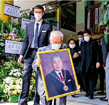 　　圖：鄉議局前主席張人龍大殮儀式昨日舉行，圖為家屬捧着張人龍的遺照步出殯儀館。