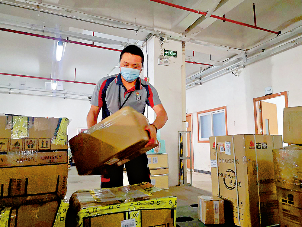 　　圖：秦文沖在裝卸貨物，作為重貨收派員要收派大件貨物。\大公報記者石華攝