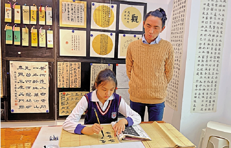 　　圖：課堂上，港青劉熙觀看學生臨摹字帖並隨時指正。\大公報記者黃寶儀攝
