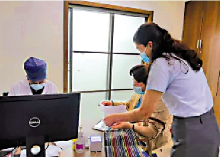 　　圖：一位職業陪診師手拿病歷本，陪伴老人在醫院檢查。\網絡圖片