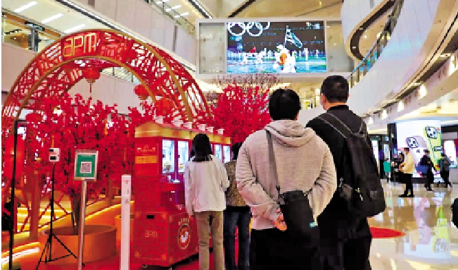 　　圖：市民在商場內駐足觀看北京冬奧開幕電視直播。\大公文匯傳媒體記者攝