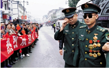　　圖：「排雷英雄戰士」杜富國，在邊境掃雷行動中面對不明爆炸物，進一步查明情況時突遇爆炸，英勇負傷，失去雙手和雙眼。圖為2020年，杜富國回到家鄉貴州過年，當地群眾自發前來歡迎，迎接英雄。