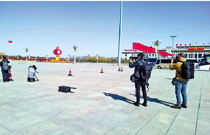 　　圖：外國記者爭相拍攝大風天裏的「紅旗招展」。\大公報記者朱燁攝