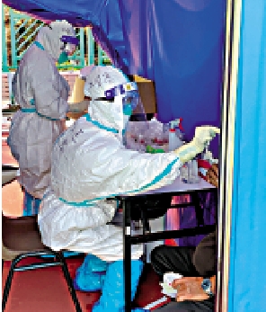 　　圖：中山大學附屬第一醫院援港核酸採樣隊張清容在採樣。\受訪者供圖