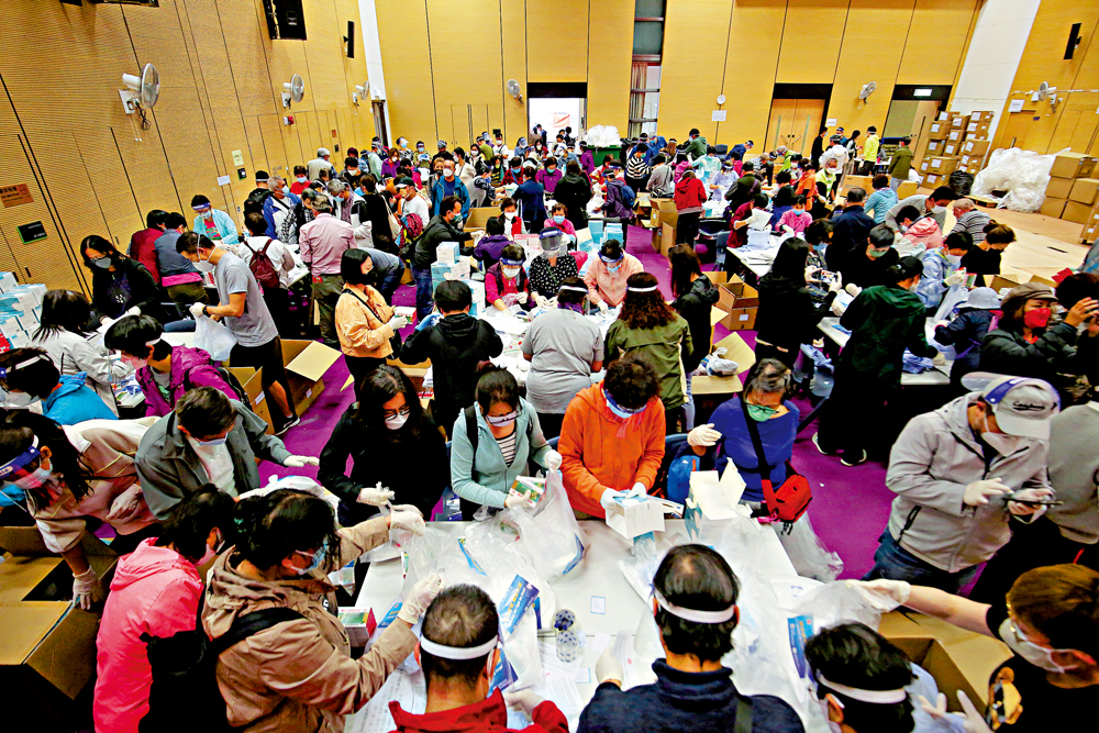 　　圖：義工們在秀茂坪社區會堂忙於製作「防疫服務包」。