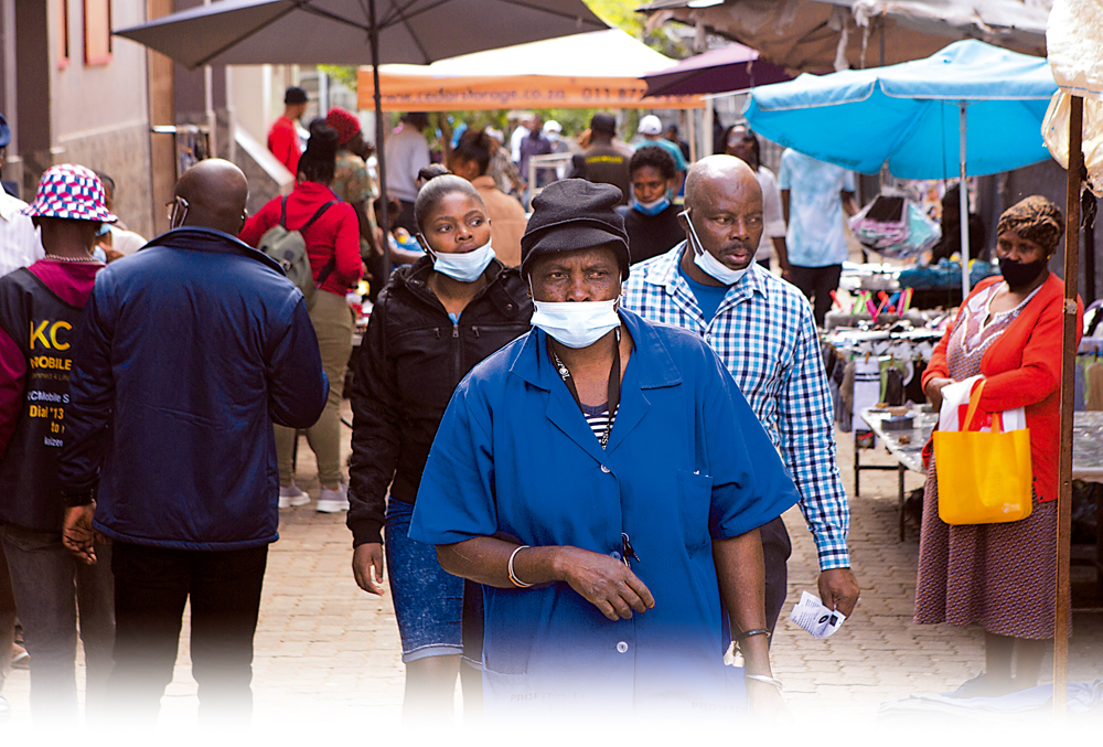 　　圖：4月5日，南非居民在街上行走時將口罩拉下。\美聯社