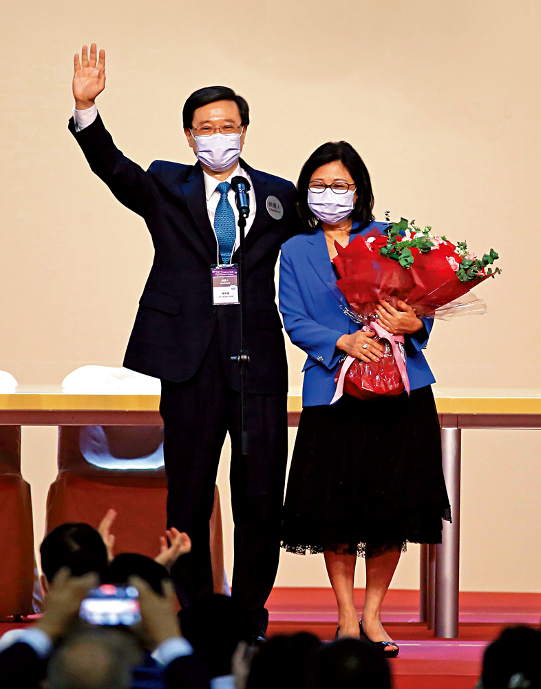 　　圖：李家超以1416票當選香港特別行政區第六任行政長官人選，他在台上發表當選感言時，向太太林麗嬋送上鮮花。\大公報記者何嘉駿攝
