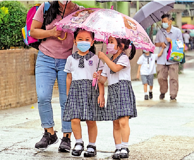圖:昨日雨勢尚不算大,小朋支撐着雨傘冒雨上學。\大公報記者蔡文豪攝