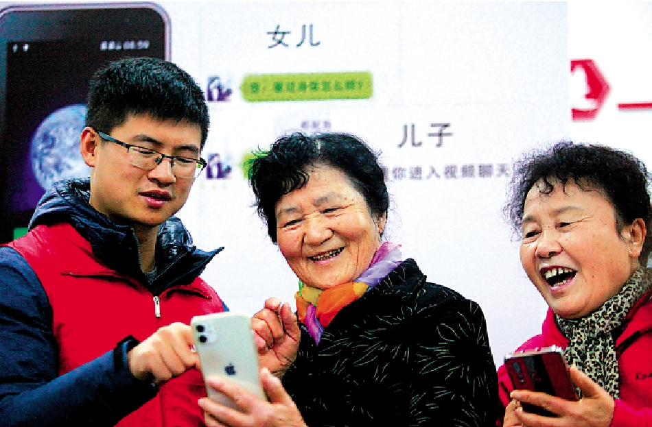　　圖：在揚州市文匯街道春江社區，志願者在教老年人使用智能手機。/新華社