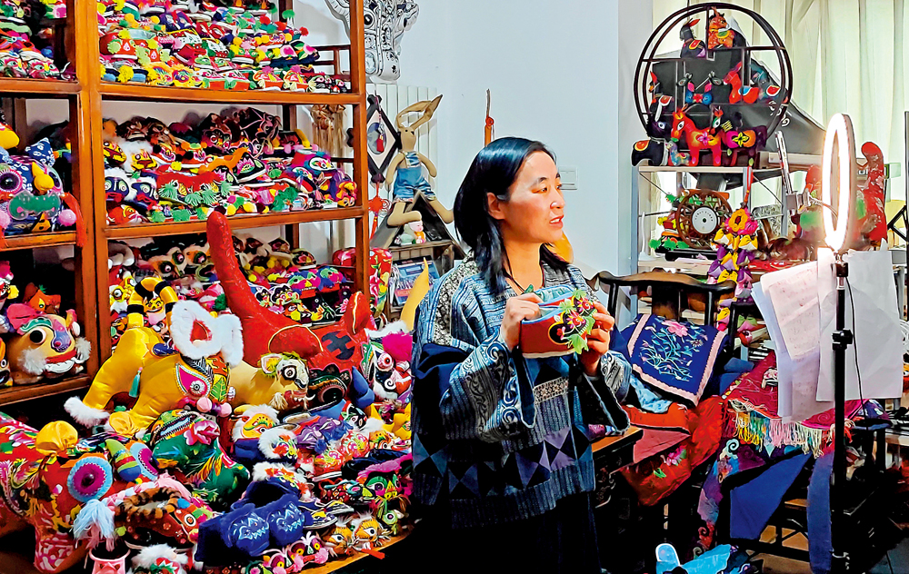 　　圖：傳統女紅收藏愛好者李茜將傳承女紅文化的工作延伸至線上。圖為李茜在直播間展示精心挑選的虎元素藏品。\大公報記者馮雷攝