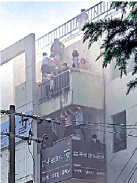 　　圖：民眾9日困在大邱起火大樓的露台上等待救援。\網絡圖片