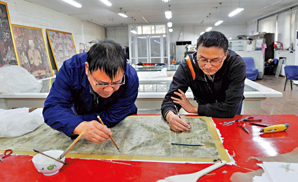 　　圖：故宮博物院的文物保護技術人員在修補絹畫。