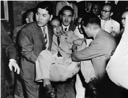 　　圖：1960年7月，岸信介（中）被右翼分子刺傷後被人抬走。/資料圖片