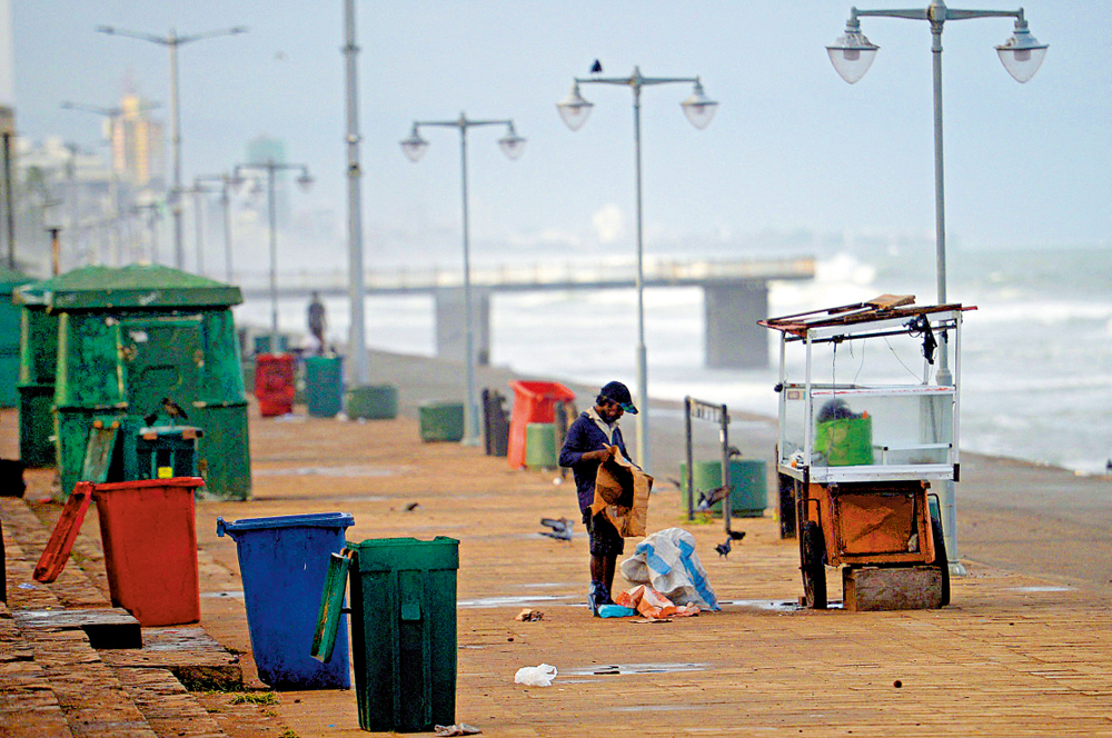 　　圖：一名斯里蘭卡男子16日在已經荒廢的海灘上拾荒。\法新社