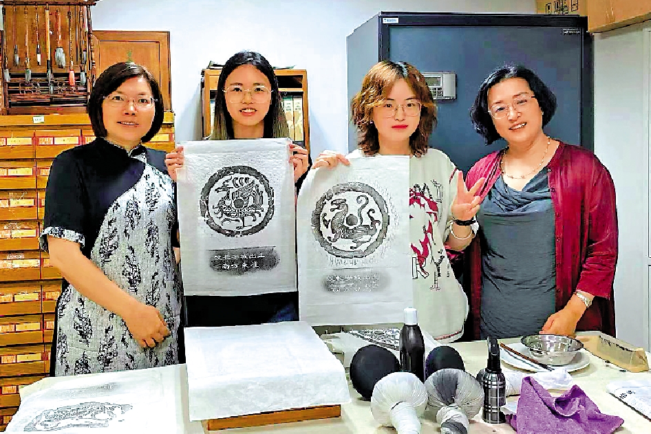 　　圖：北京語言大學的港生曾冰兒（右二）、朱倩婷（左二）在實習結束後與老師合影，並展示自己的傳拓作品。\受訪者供圖