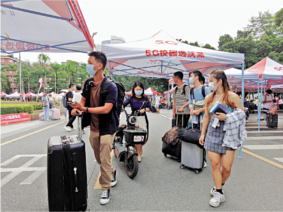 　　圖：拉着黑色行李箱，背着行囊，港生鄭益昌（左一）來到暨南大學門口。\大公報記者盧靜怡攝