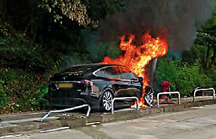 　　圖：一輛Tesla黑色電動車昨日在寶琳北路康盛花園對開一個上斜右彎失控，猛撼燈柱，車頭瞬間起火，車上二人及時棄車逃生。