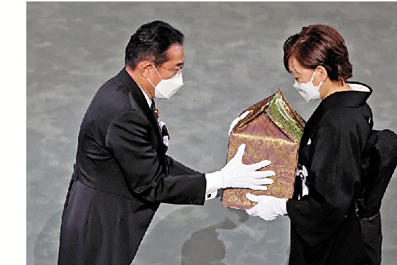 　　圖：岸田文雄將安倍的骨灰盒遞交給其遺孀安倍昭惠。\法新社