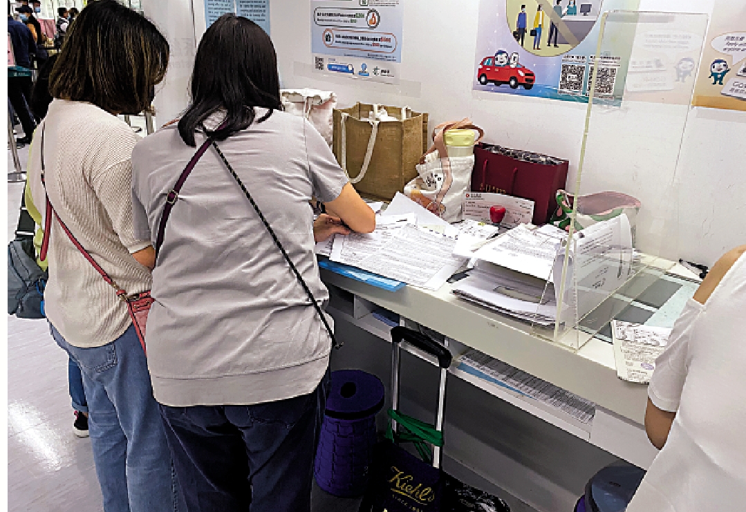 　　圖：排隊黨幫客戶代辦的文件攤開在櫃枱上，私隱隨時洩露。