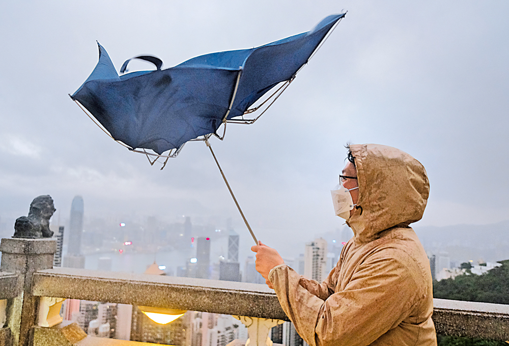 　　圖：有市民到山頂追風，雨傘被吹反，狀甚狼狽。\大公報記者蔡文豪攝