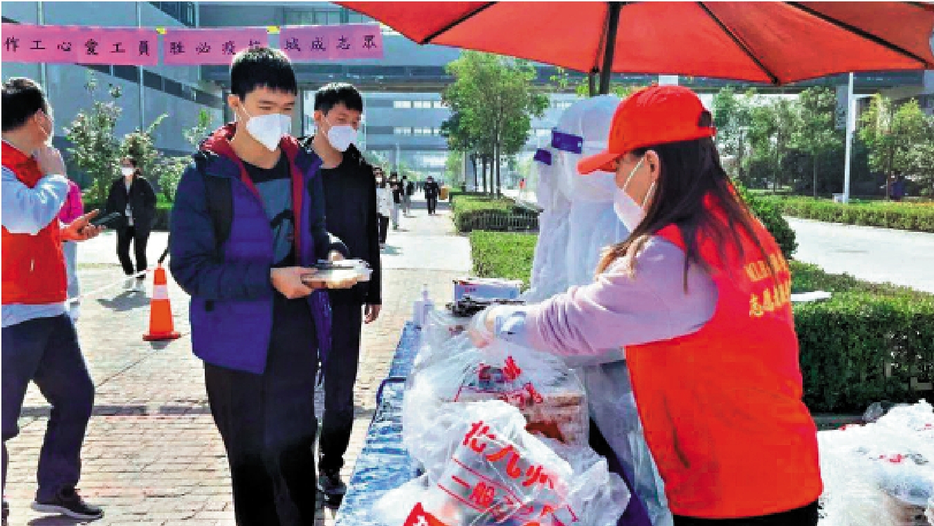 　　圖：河南鄭州富士康航空港廠區員工志願者為上班同事發放公司提供的餐食。