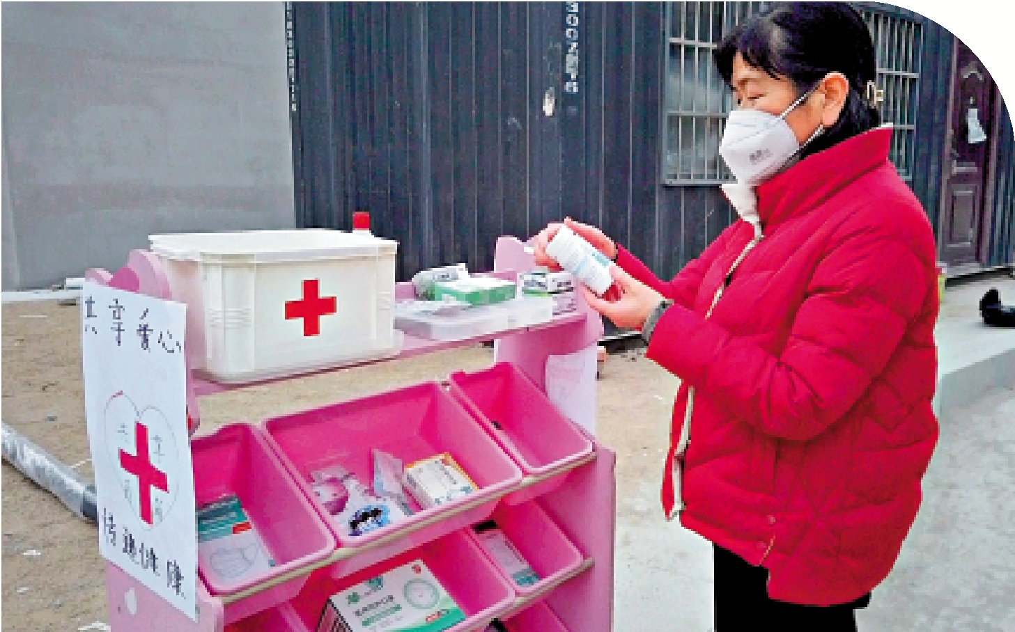 　　圖：一位鄰居在崔京軍設置的「共享藥箱」前選擇藥品。/受訪者供圖