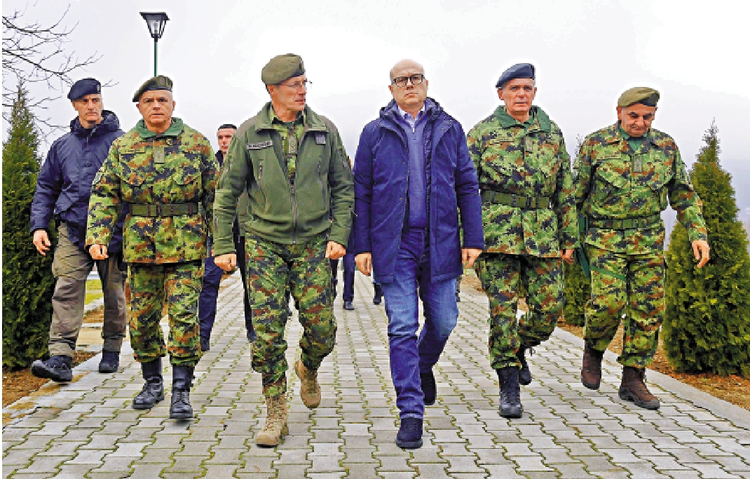 　　圖：塞爾維亞防長武切維奇（中）等人26日在塞國南部的軍營巡視。\美聯社