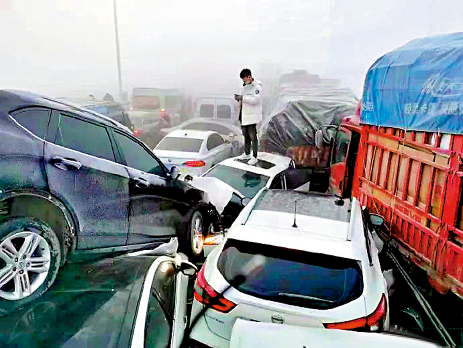 　　圖：大橋上多輛車相撞，有的甚至疊在一起，有司乘人員在四周或拍照或察看車輛受損情況。\網絡圖片
