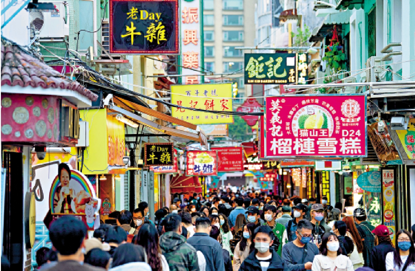 　　圖：2023年1月1日元旦假期，澳門中區人來人往，市面暢旺。不少旅客來澳門跨年，感受節日氣氛。圖為旅客在澳門官也街選購小食。/中通社