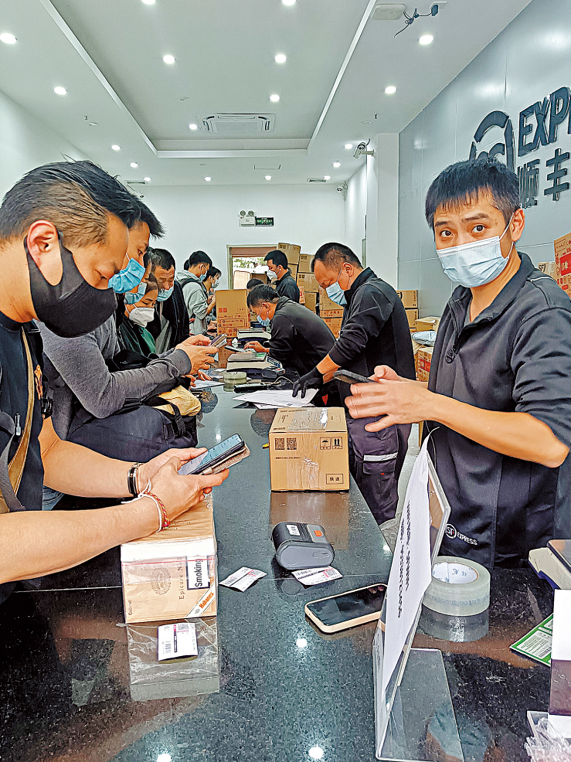 　　圖：大量港人湧入順豐福田口岸店寄快遞，業務員忙得不可開交。\大公報記者李昌鴻攝