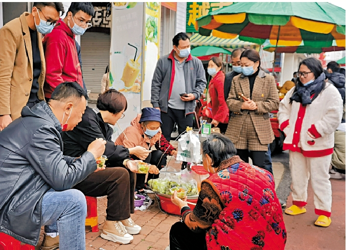 　　圖：東興街頭「屈頭蛋」攤位前聚集了品嘗美食的遊人。\大公報記者蘇徵兵攝