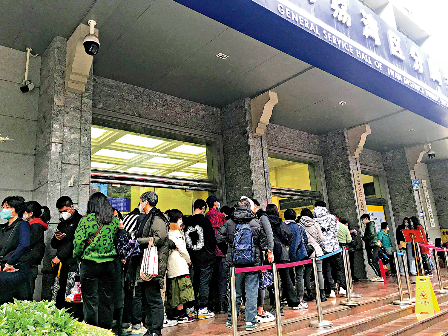 　　圖：廣州民眾冒雨前來辦理簽註，荔灣區公安分局出入境辦證中心大排長龍。\大公報記者敖敏輝攝