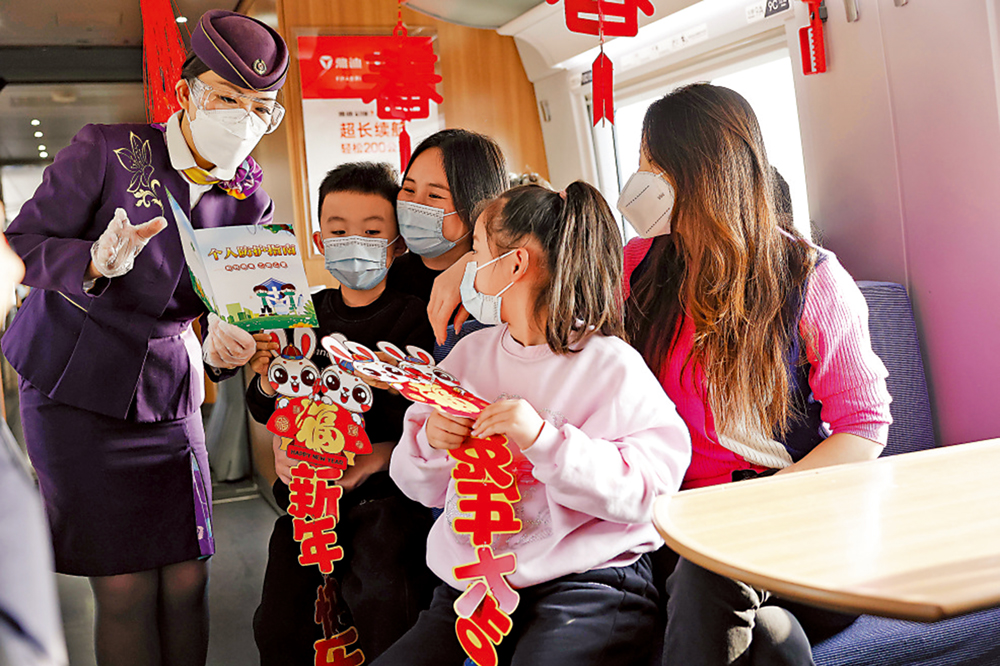 　　圖：1月7日，在由上海虹橋開往昆明南的G1373次列車上，乘務長向旅客介紹防疫知識。\中新社