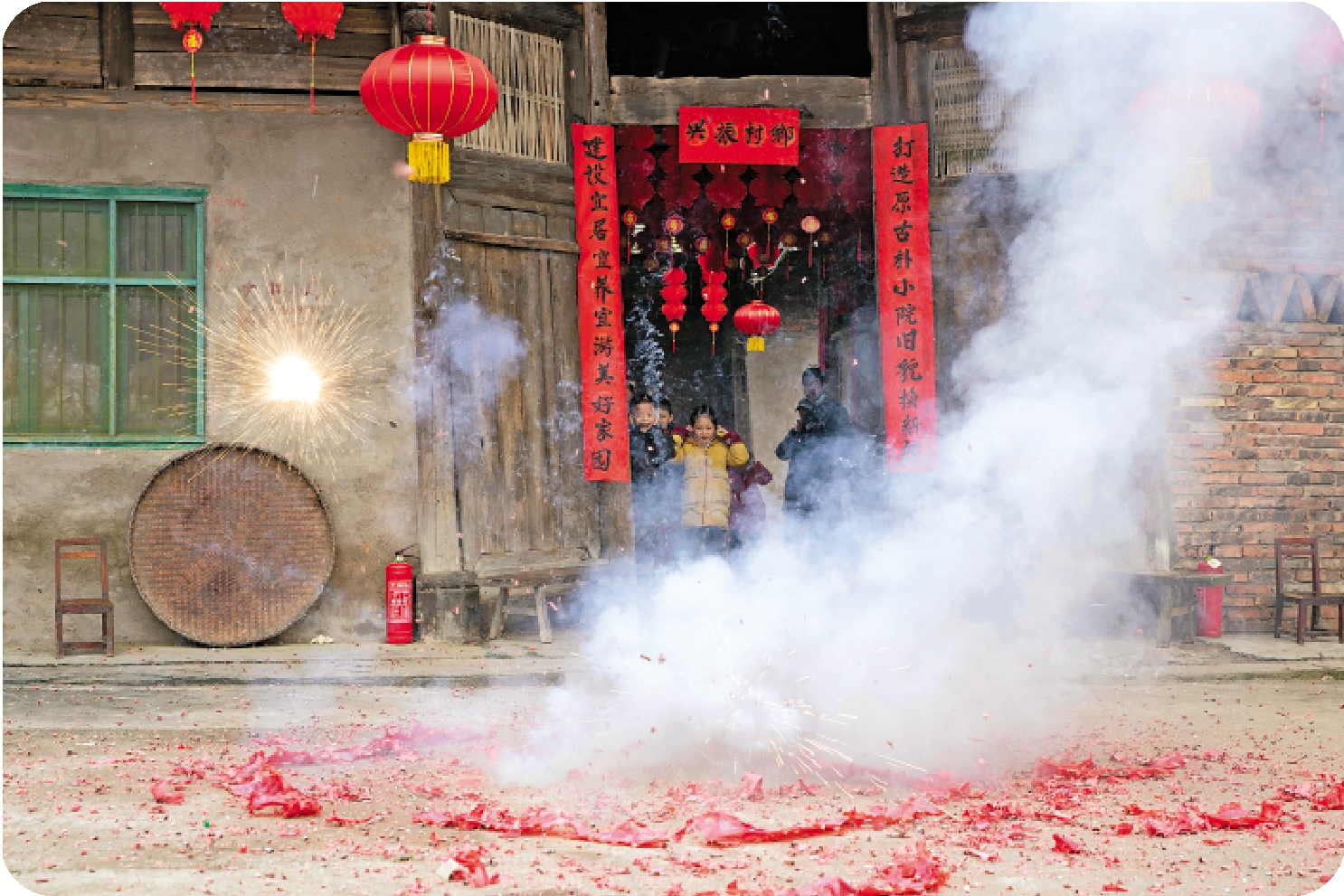 　　圖：2021年農曆新年，四川省花灘鎮齊心村李家大院居民們在大院門口放起鞭炮。