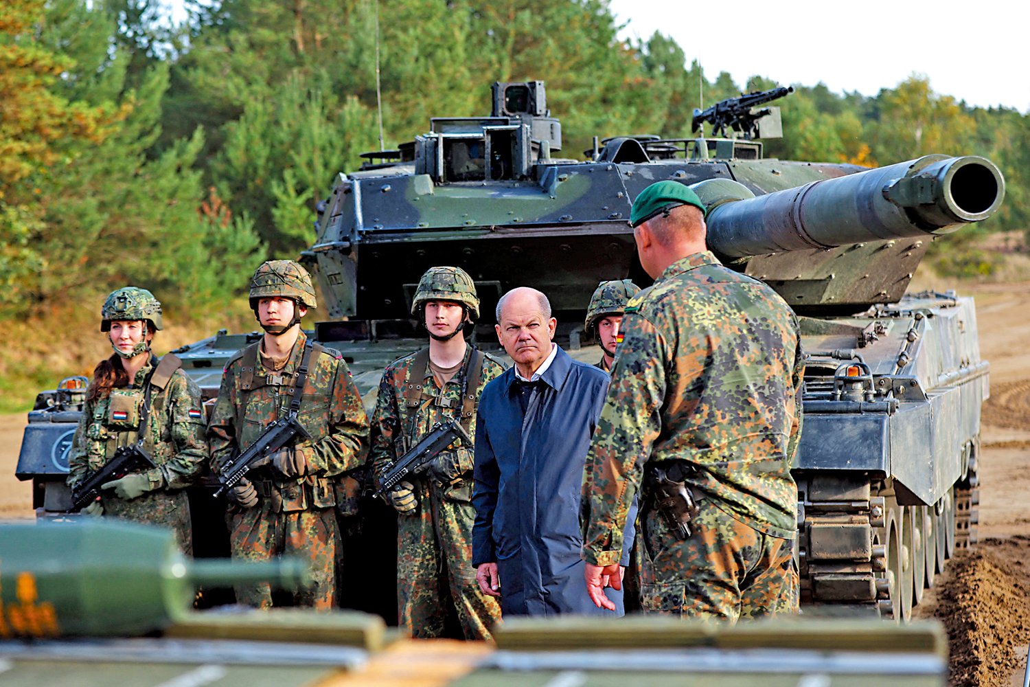 　　圖：德國25日鬆口援烏主戰坦克，圖為朔爾茨（中）視察「豹2」坦克部隊。\法新社