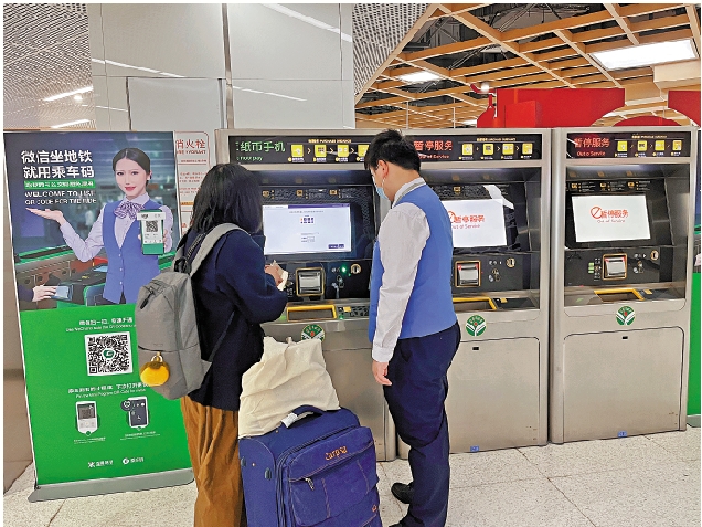 　　圖：港鐵工作人員在指引乘客使用自助售票機購票。\大公報記者郭若溪攝